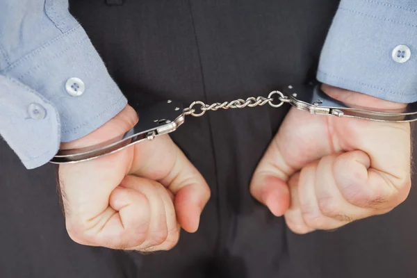 Businessman in handcuffs clenching fists — Stock Photo, Image