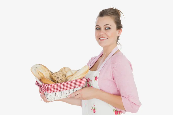 Jovem mulher segurando cesta cheia de pães — Fotografia de Stock