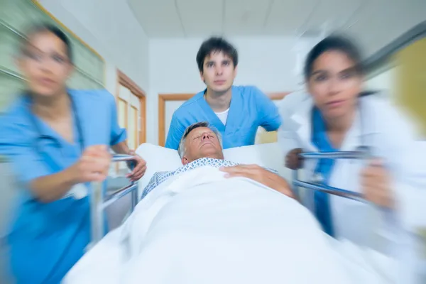 Equipe de médico correndo em um corredor do hospital — Fotografia de Stock