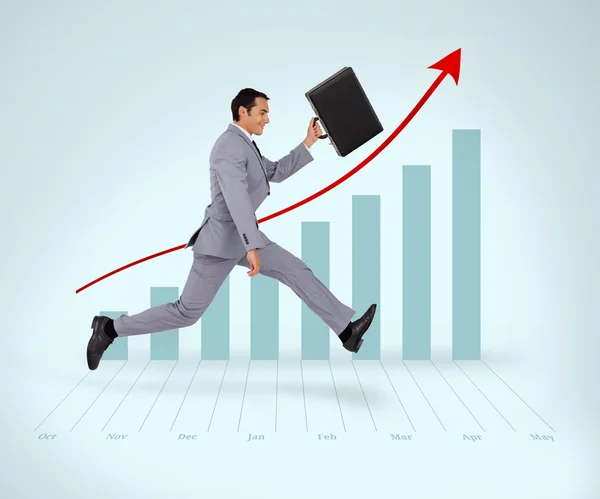 Man in suit running against a graph — Stock Photo, Image