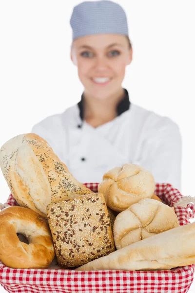 Chef feminino com vários pães na cesta — Fotografia de Stock