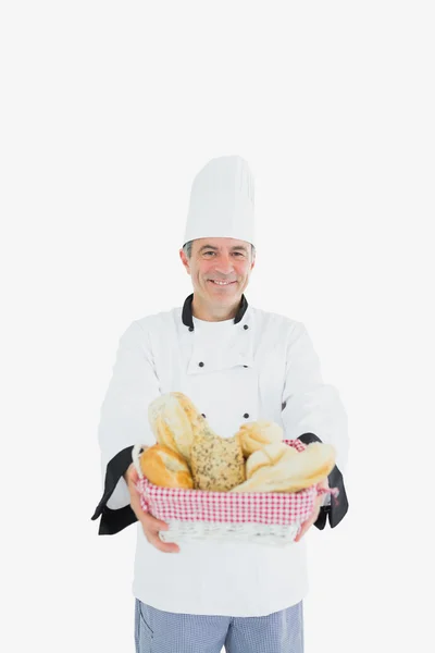 Мужчина-повар держит свежий хлеб в корзине — стоковое фото