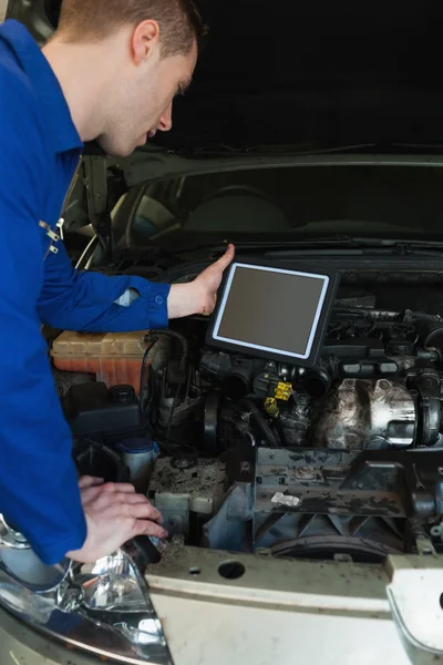 Mechanic by car holding tablet pc — Stock Photo, Image