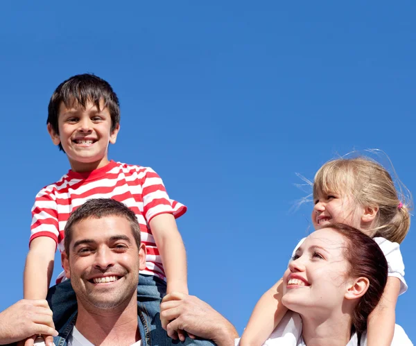 Gelukkige ouders hun kinderen piggyback raken geven — Stockfoto