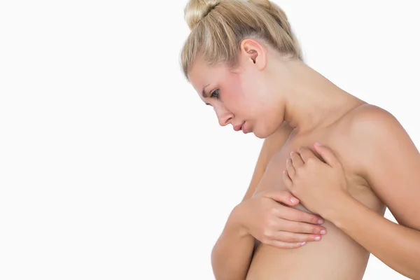 Serious naked woman covering breast — Stock Photo, Image