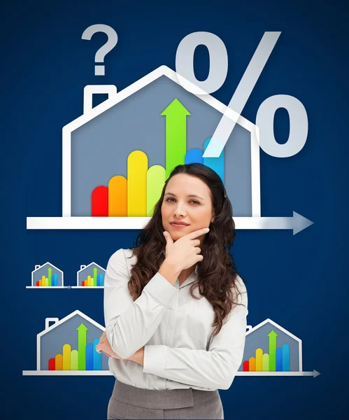 Thinking businesswoman standing against a energy efficient house — Stock Photo, Image