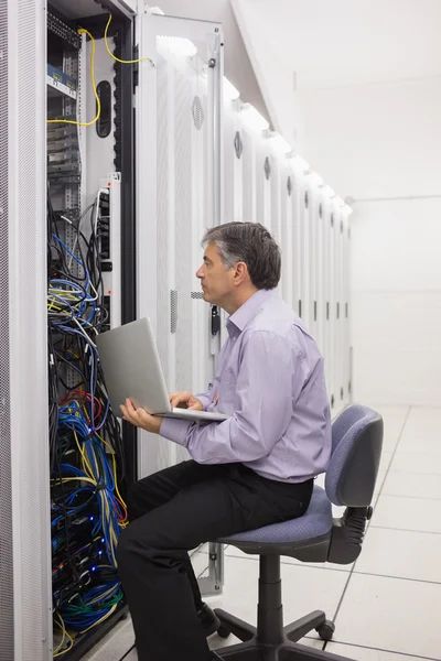 Técnico comprobando el servidor con su portátil — Foto de Stock