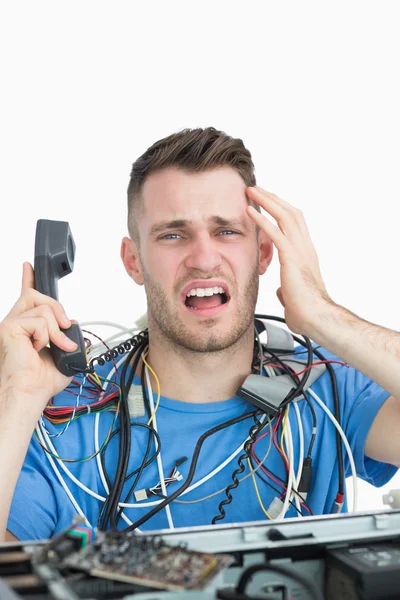 Portrait of frustrated computer engineer on call in front of ope — Stock Photo, Image