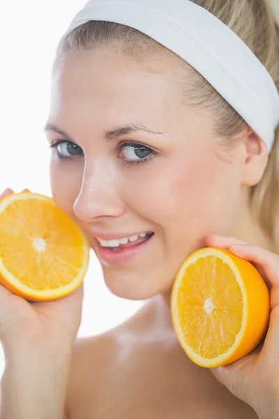 Hermosa mujer sosteniendo rodajas de naranja — Foto de Stock