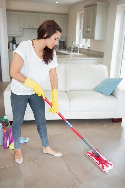 Mulher limpando o chão da sala de estar — Fotografia de Stock