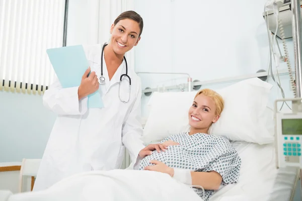 Obstetra feminina conversando com uma mulher grávida sorridente — Fotografia de Stock