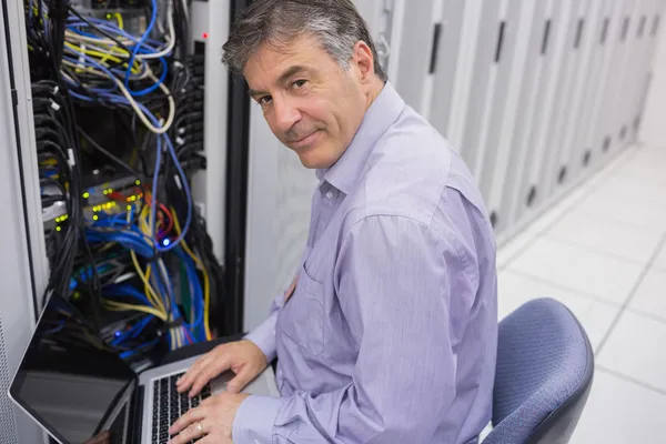 Hombre haciendo mantenimiento del servidor con portátil —  Fotos de Stock