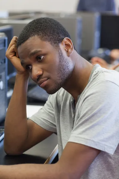 Студент выглядит расстроенным в компьютерном зале — стоковое фото