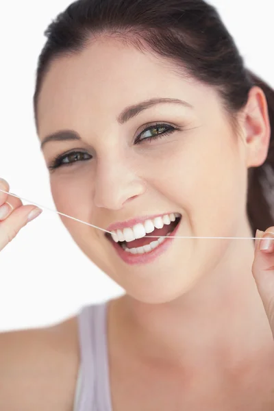 Mujer sonriente usando hilo dental — Foto de Stock