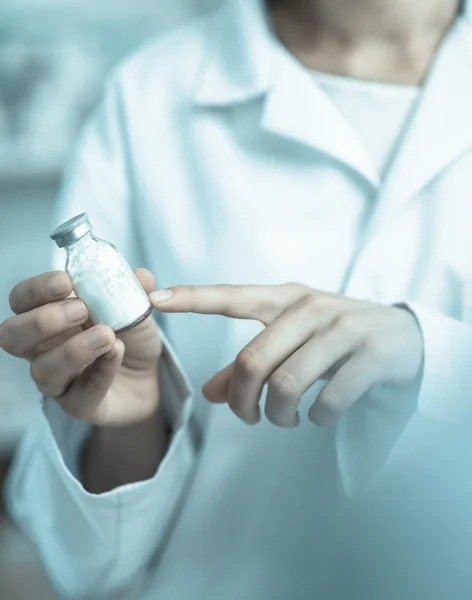 Vial being pointing at by a person in a laboratory coat — Stock Photo, Image