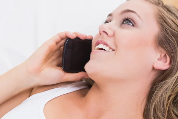 Blonde woman phoning in the bedroom — Stock Photo, Image