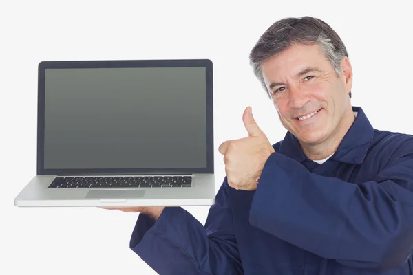 Mechanik s laptop ukazuje palec nahoru znamení — Stock fotografie