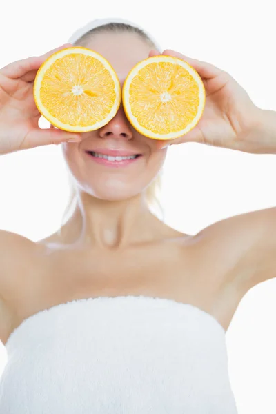 Mulher feliz cobrindo olhos com fatias de laranja — Fotografia de Stock