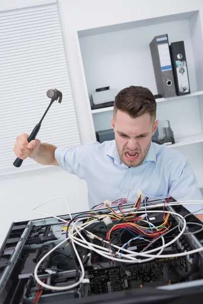 Frustrated man hitting cpu with hammer — Stock Photo, Image