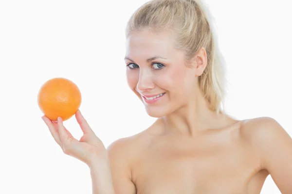Portrait of happy topless woman holding fresh orange over white background ...