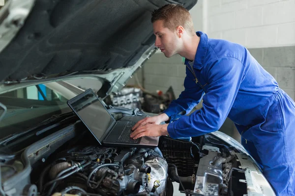 Mechanik auto pracuje na laptopie — Zdjęcie stockowe