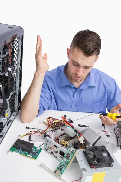 Jovem engenheiro de computação confuso fixando peças de computador — Fotografia de Stock