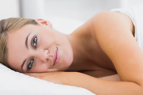 Lächelnde Frau liegt auf ihrem Bett — Stockfoto