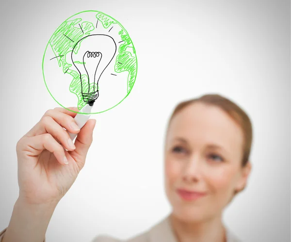 Woman drawing picture of globe and bulb — Stock Photo, Image