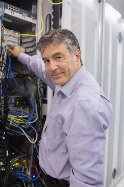 Homem fixando fios enquanto sorri — Fotografia de Stock