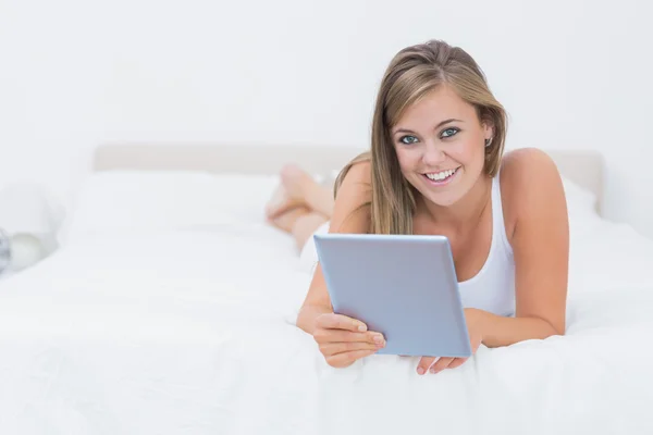 Lächelnde blonde Frau mit ihrem Tablet-PC — Stockfoto