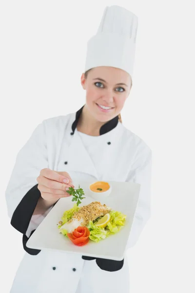 Female chef seasoning meal with parsley — Stock Photo, Image