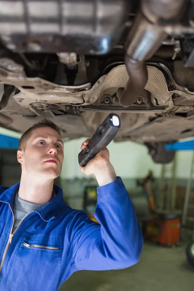 Reparateur mit Taschenlampe untersucht unter Auto — Stockfoto