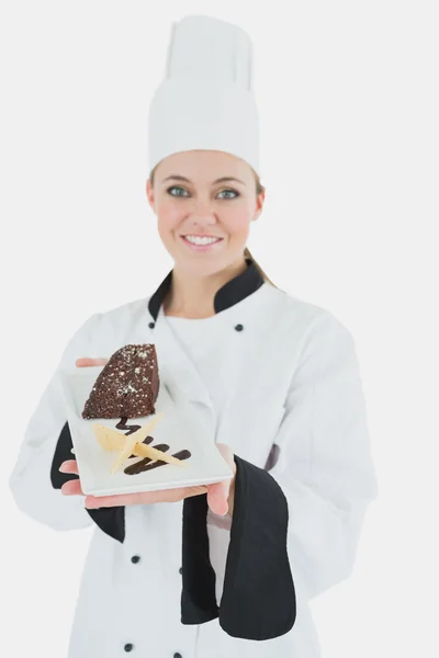 Happy young chef holding plate of pastry — Stock Photo, Image