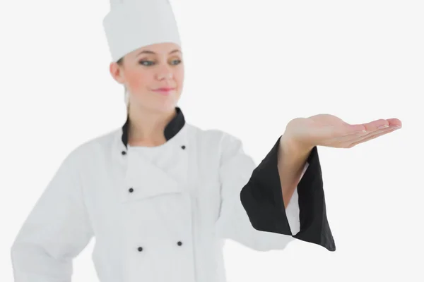 Chef em uniforme olhando para o produto invisível — Fotografia de Stock