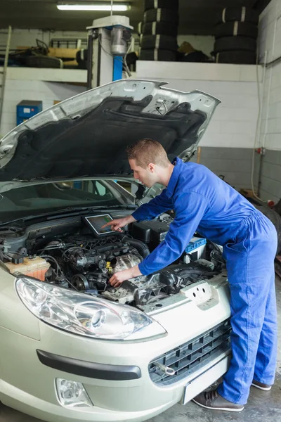 Männlicher Mechaniker analysiert Auto-Motor — Stockfoto