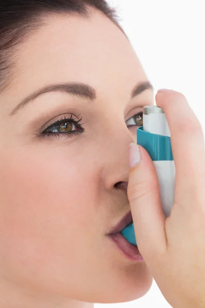 Brunette woman using asthma inhaler — Stock Photo, Image