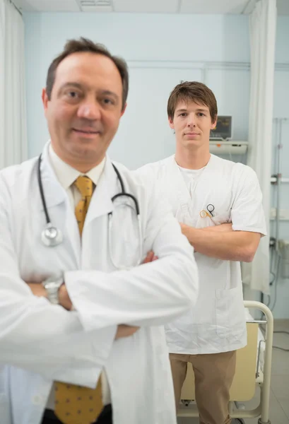 Dottore e un infermiere maschio incrociando le braccia — Foto Stock