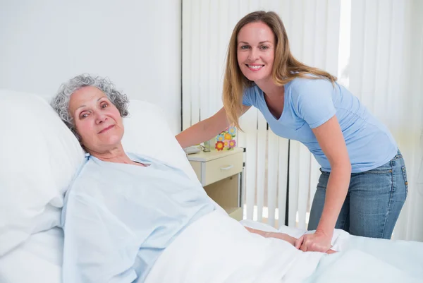 Woman holding the hand of a patient in a room — Stock Photo, Image