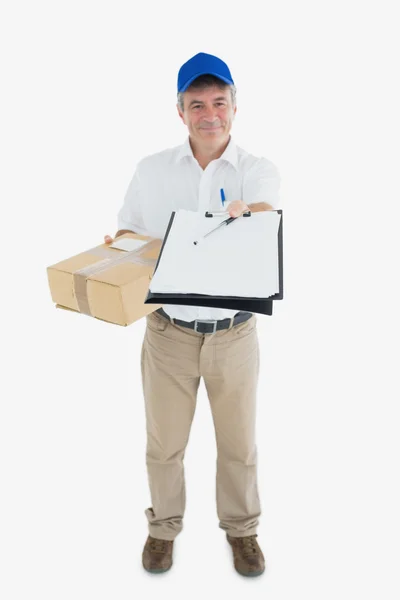 Courier man with package holding out clipboard — Stock Photo, Image