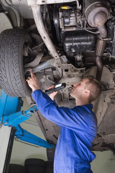 Automechaniker untersucht unter Auto — Stockfoto