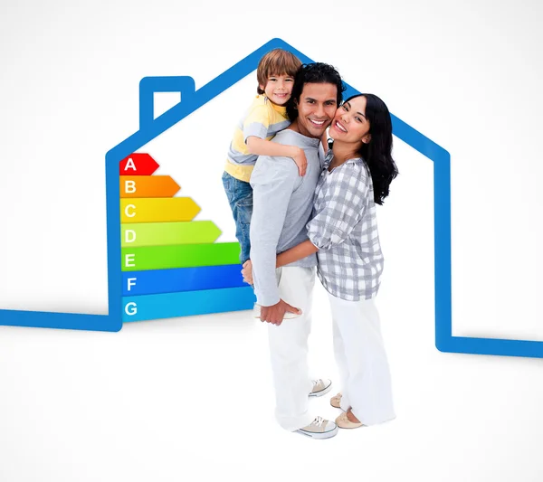 Smiling family standing with a blue house illustration with ener — Stock Photo, Image