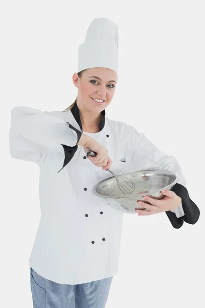 Happy female chef holding wire whisk and mixing bowl — Stock Photo, Image