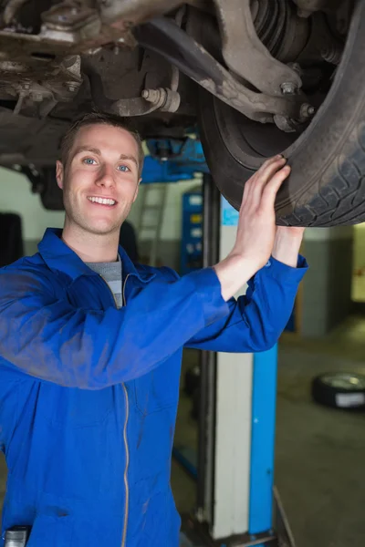 Heureux mécanicien examinant pneu de voiture — Photo