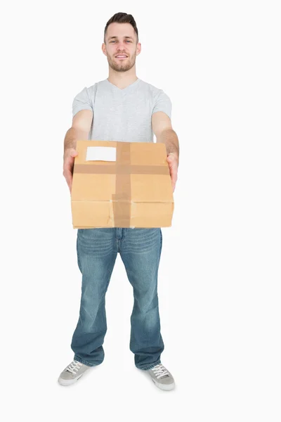 Portrait of young man giving you a package box — Stock Photo, Image