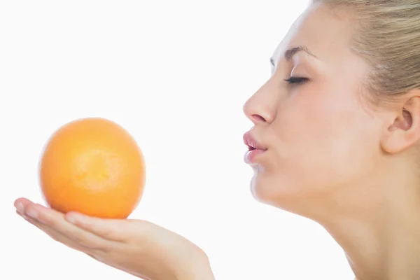 Kobieta dmuchanie pocałunek na pomarańczowy — Zdjęcie stockowe