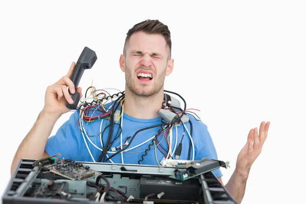 Frustrated computer engineer on call in front of open cpu — Stock Photo, Image