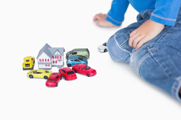 Крупним планом хлопчик грає з ігровим будинком та іграшковими машинами — стокове фото