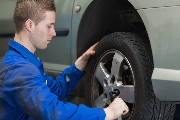 Male mechanic changing car wheel Stock Picture