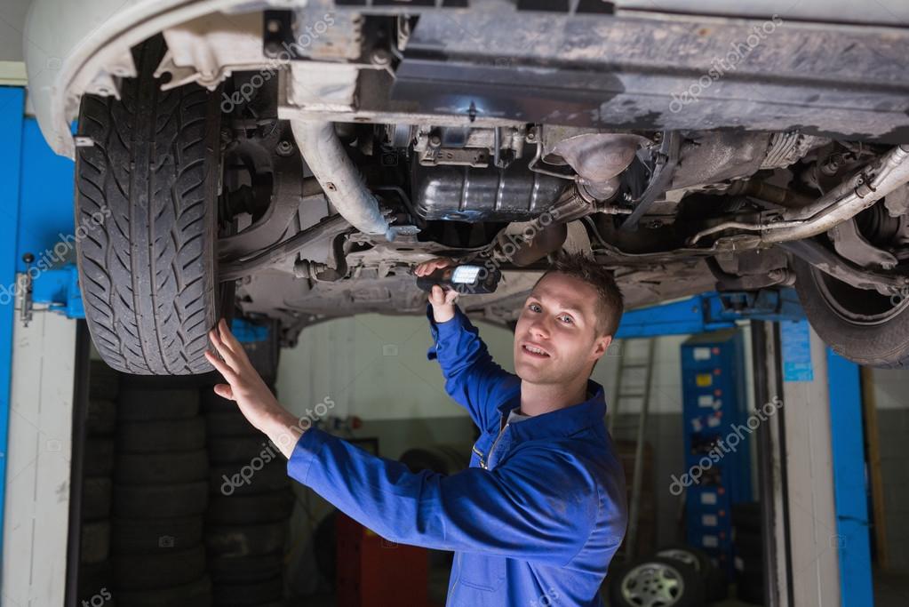 mechanic with flashlight under car stock photo wavebreakmedia