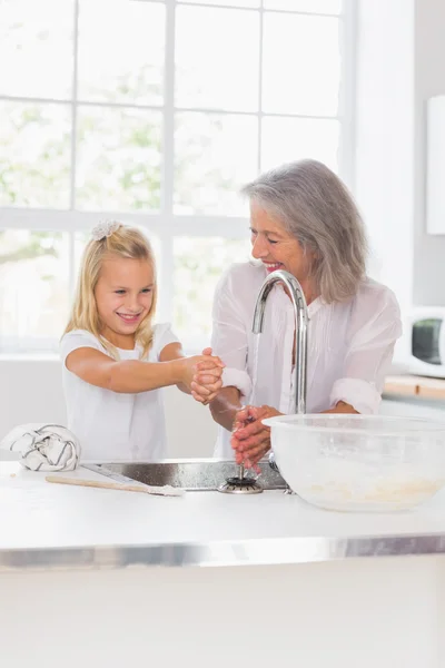 Smiling grandmother and granddaughter washing hands — Stock Photo, Image